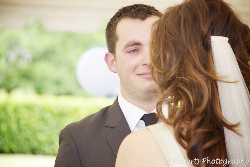 Groom looking into brides eyes during marriage ceremony - wedding photography sydney